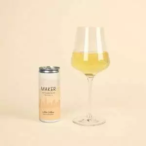 A glass of Maker Wine Chenin Blanc by Colleen Clothier next to a can of the same wine by Colleen Clothier.