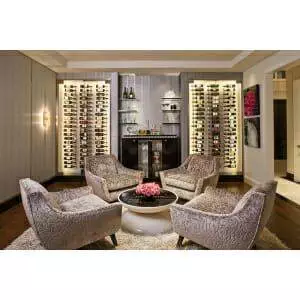 A living room with chairs and a W Series 3′ Wall Mounted Metal Wine Rack for 9 bottles.