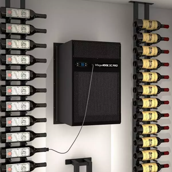 Wall-mounted WhisperKOOL SC PRO unit with temperature display cooling a room with bottles of wine on metal racks.