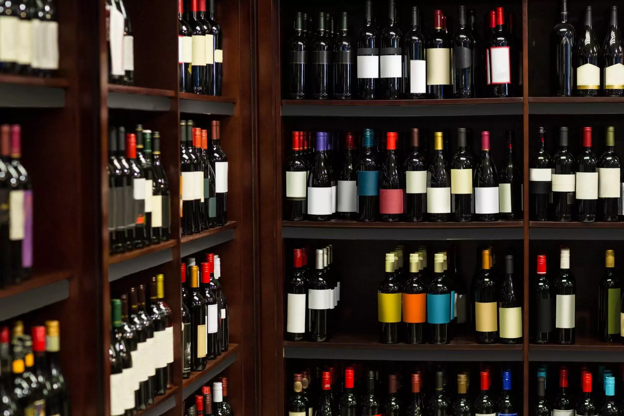 Shelves filled with various bottles of wine, each adorned with different labels, await you in a wine store or cellar setting. Whether you're seeking expert advice or considering the perfect wine rack, our selection caters to all preferences and sizes.