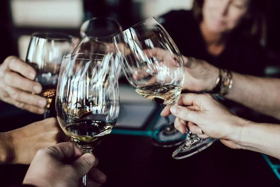 Several hands clinking wine glasses together in a toast, with one person partially visible in the background.